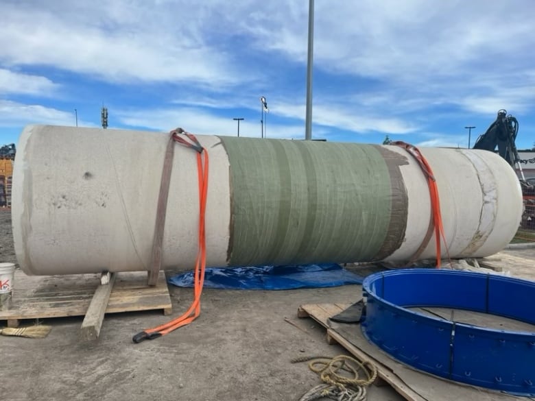 a large pipe that rests on top of some heavy equipment.