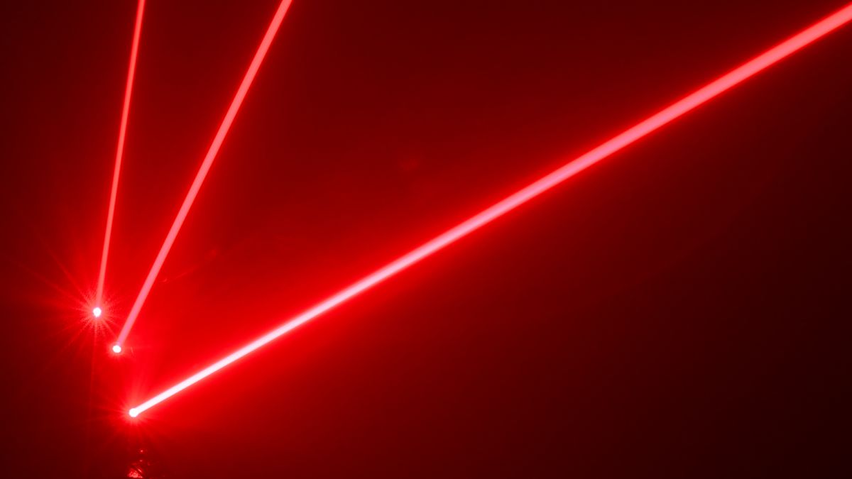 Three red laser beams shooting out from the bottom left-hand corner